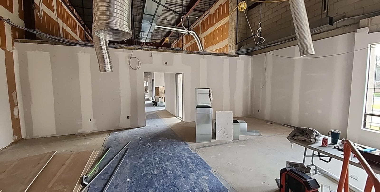 Commercial room with taped drywall partitions, doorway openings and exposed ventilation ducts
